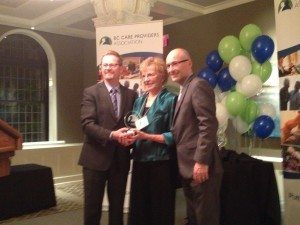 Louise Johnson receives the Innovation of the Year Award from Health Minister Terry Lake and CEO Daniel Fontaine